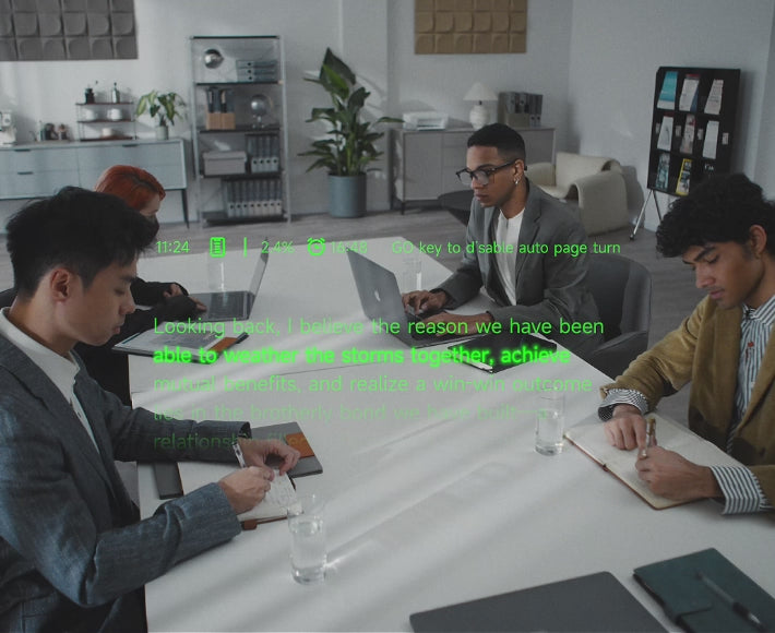 People seated around a meeting table with green teleprompter text floating in view