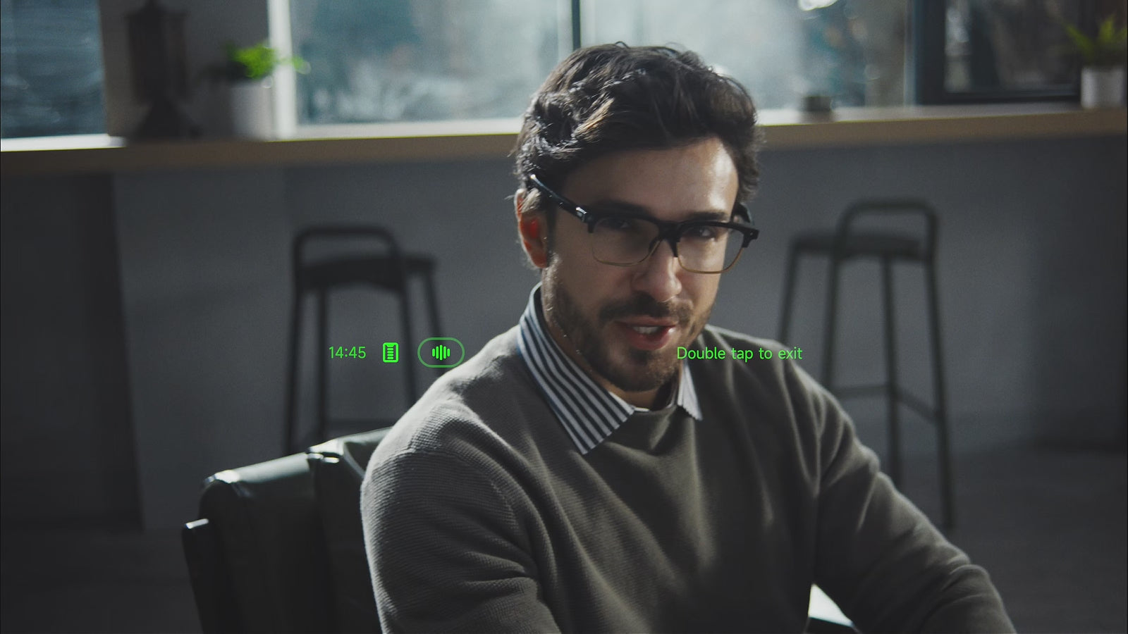 A man wearing INMO GO3 speaks while seated, with a green subtitle interface status bar and a Double tap to exit prompt shown in the frame